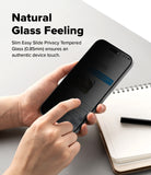 iPhone 18 Pro Screen Protector | Easy Slide Privacy Tempered Glass - A person holds a smartphone with a dark privacy screen protector in both hands over a light gray desk, with a notebook and pen nearby. Text on the left reads 'Natural Glass Feeling' and describes slim easy slide privacy tempered glass.