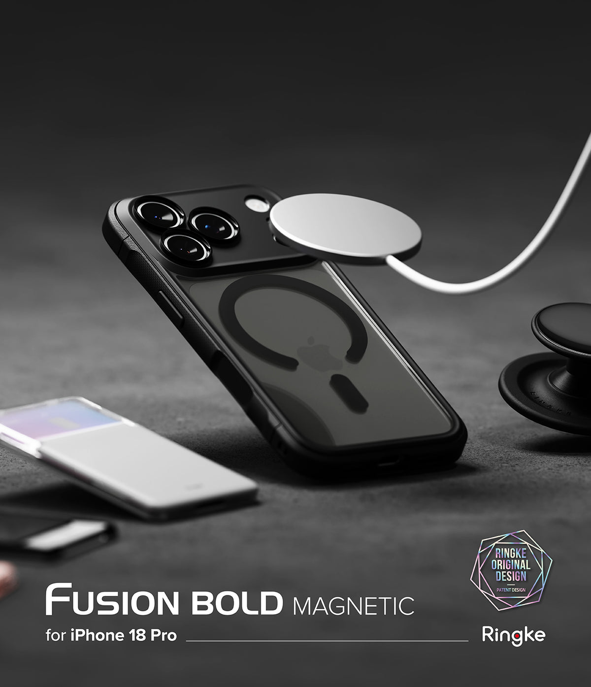 iPhone 18 Pro Case | Fusion Bold Magnetic Matte - A black magnetic phone case for iPhone 18 Pro, shown with a white MagSafe ring accessory. The image is set on a dark textured surface with a smartphone and a pop socket in the background, featuring branding for Ringke and Fusion Bold Magnetic.