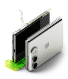 iPhone Duo | Hinge Dual Easy Film (2P) - A silver Apple iPhone shown from the back, partially inserted into a bright green stand, with a transparent protective film being peeled off the screen. The Apple logo is visible on the device.