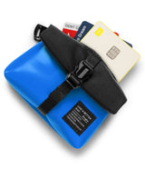 Mini Pouch Tarpaulin | Roll Top - Blue tarpaulin pouch with a black roll-top closure, buckle strap, and credit cards tucked inside.