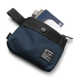 Mini Pouch | 2-Way Bag Miniature - Navy blue zippered pouch containing credit cards and a white wireless earbud case.