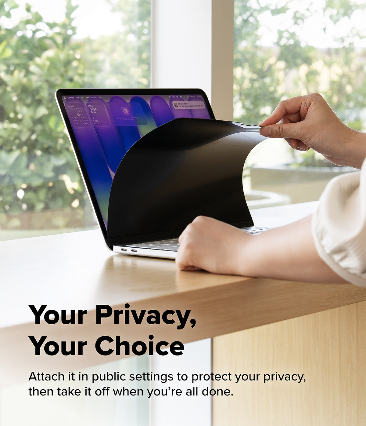 MacBook Neo Case + Protector all-groups - A person's hands peel off a black privacy film from a laptop screen on a light wood desk, with a blurred outdoor background and the text 'Your Privacy, Your Choice' on the lower left.