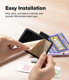Pen Holder | Name Tag (2P) - A person's hands demonstrate the easy installation of a black magnetic wallet or card holder with a black velcro strap. The product is shown being peeled from its beige double-sided adhesive backing and attached to a black surface.
