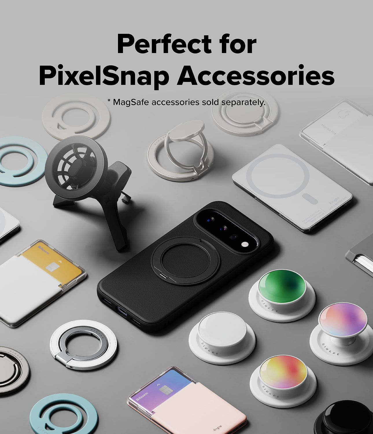 Google Pixel 11 Case | Onyx Ring - A black PixelSnap-style phone case with a circular MagSafe ring is shown in a styled flat-lay arrangement with multiple white and colored magnetic accessories, rings, stands, and a folded phone. Text at the top reads, 'Perfect for PixelSnap Accessories' with a smaller note that MagSafe accessories are sold separately.