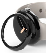 Google Pixel Watch 41mm | Premium Bezel Styling - Google Pixel Watch 41mm - A black textured bezel accessory hovering over a black smartwatch with a light grey band.