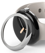 Google Pixel Watch 41mm | Premium Bezel Styling - A silver, fluted watch bezel hovering over a black Pixel Watch.