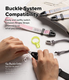 Design Shoulder Strap - Person wearing a light gray camera strap with a small brand tag attached to a vintage-style camera.