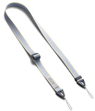Design Shoulder Strap - A clear phone case attached to a grey adjustable shoulder strap resting on an open book.