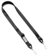 Design Shoulder Strap - Person wearing a black branded shoulder strap attached to a clear smartphone case over a yellow sweater.