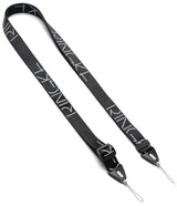 Design Shoulder Strap - Person wearing a black branded shoulder strap attached to a smartphone in a black case.
