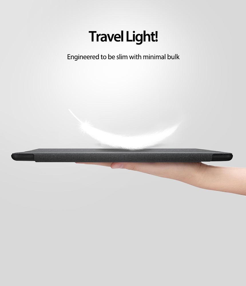 Smart Cover Apple Pencil Stand | iPad - A hand holds a slim black tablet or case horizontally against a light gray background, with marketing text above reading 'Travel Light! Engineered to be slim with minimal bulk' and a white feather graphic above the device.