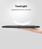 Smart Cover Apple Pencil Stand | iPad - A hand holds a slim black tablet or case horizontally against a light gray background, with marketing text above reading 'Travel Light! Engineered to be slim with minimal bulk' and a white feather graphic above the device.