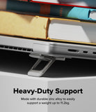 Step-Fit Mini Stand - A close-up of a silver laptop stand supporting a silver laptop, with books stacked on top in a blurred background. Text at the bottom reads 'Heavy-Duty Support' and 'Made with durable zinc alloy to easily support a weight up to 11.