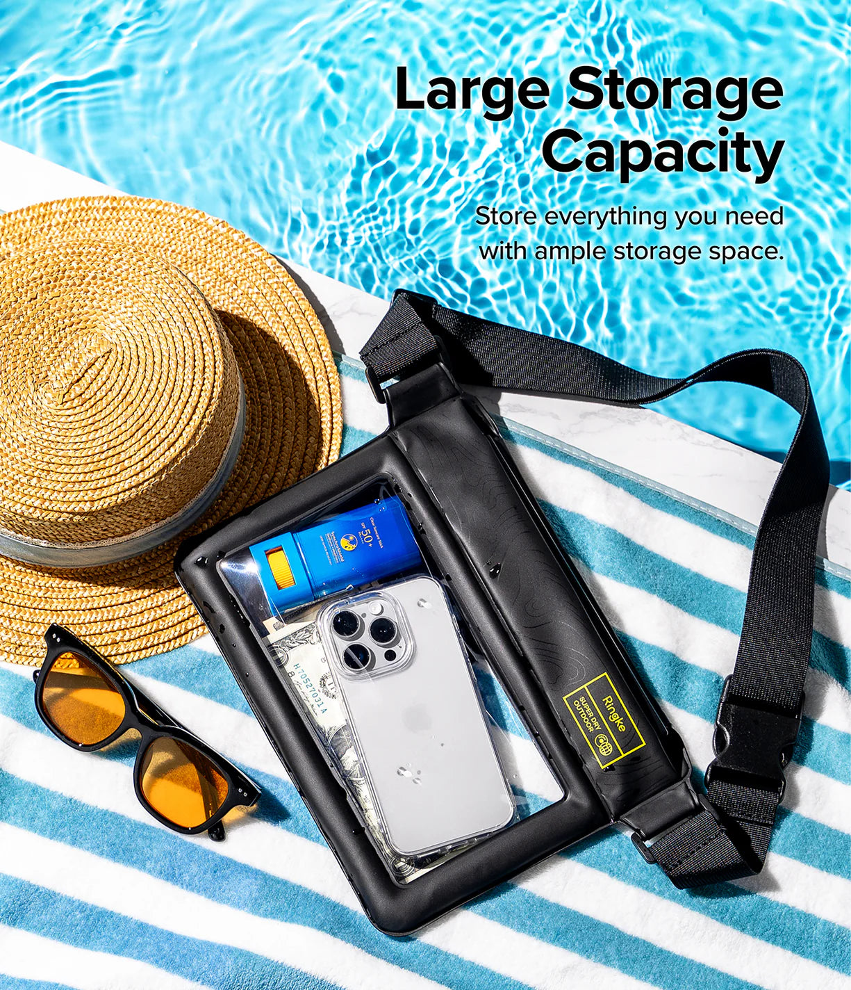 Palm Leaves / Navy Stripes Floating Strap & Waterproof Sling Bag | Black waterproof bag with phone and sunglasses on a striped towel by a poolside, emphasizing large storage capacity.